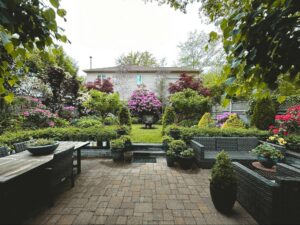 Cohesive New England backyard with a paver patio, integrated seating areas, and spring blooms representative of JRD Landscape Design's work.