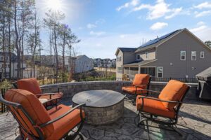 Fire pit design with a curved seat wall and paver patio seating area.