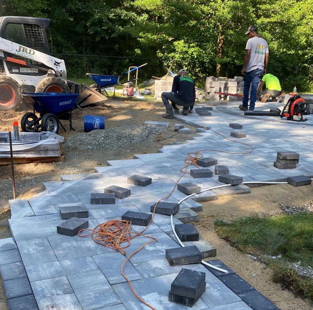 JRD Landscape Design crew installing pavers on a hardscape project in Scituate, MA.