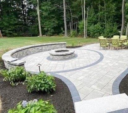 Outdoor firepit and curved stone seating wall on a paver patio in Hingham, MA.