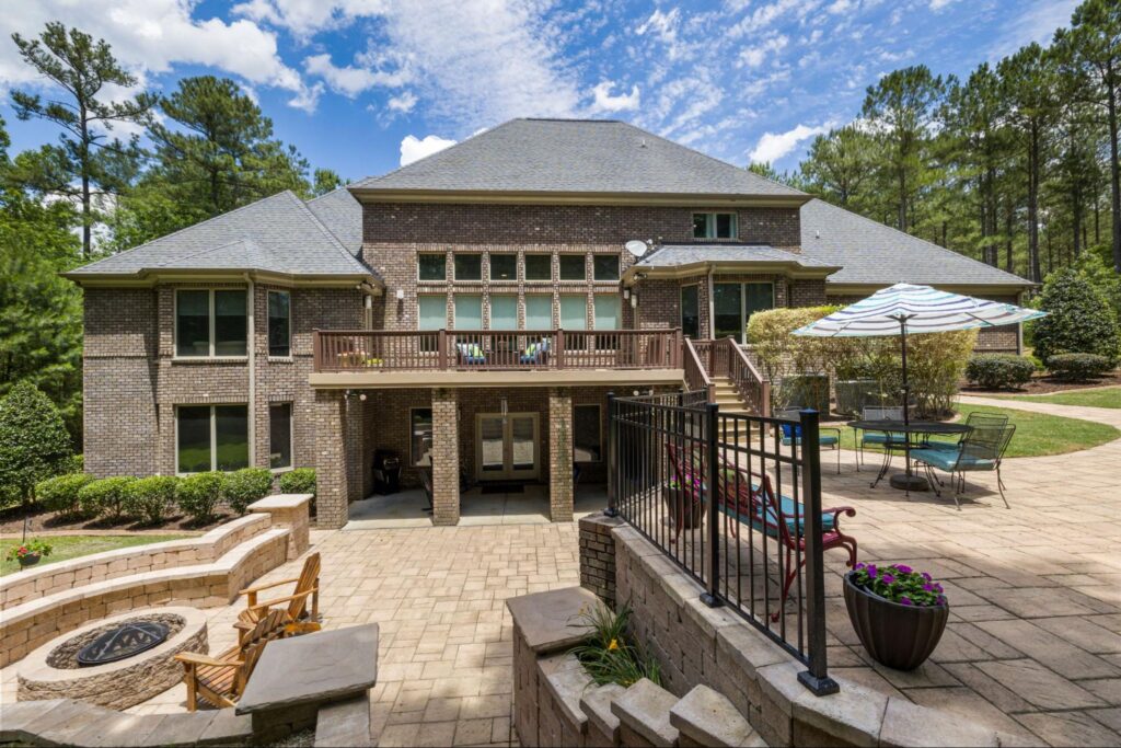 An outdoor patio with a seat wall and fire pit at a Hanover, MA home.
