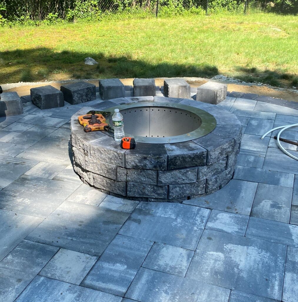 Fire pit installation in Norwell, MA with paver patio and block seating.